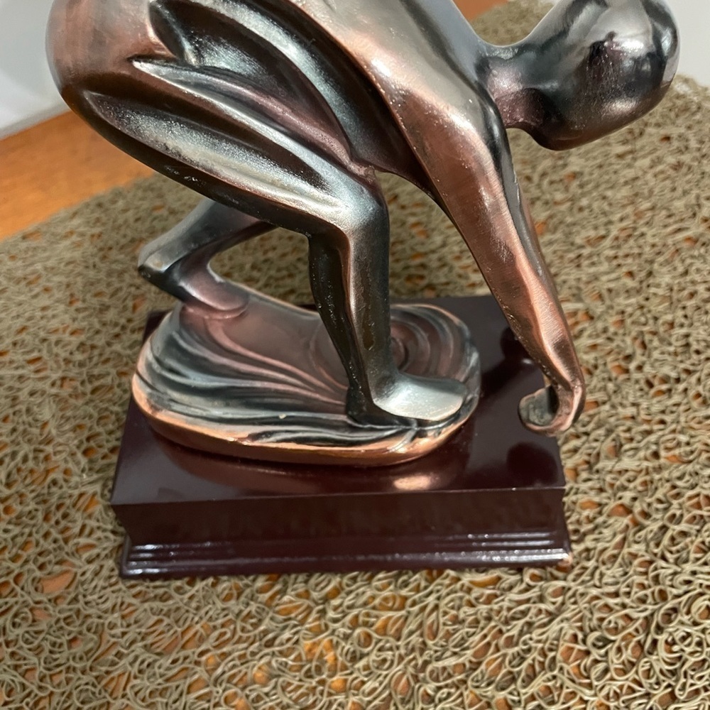 Male Ceramic Sculpture in bronze color on a wooden base.
